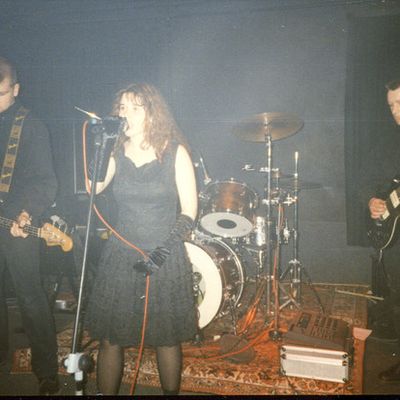 Die Band auf einer Bühne: Saxophon, Bass, Sängerin am Mikrofon, Schlagzeug und Gitarre